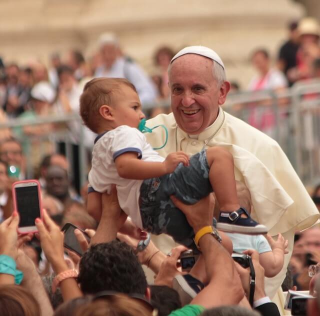 교황님이 아이를 안고 미소 짓고 있습니다. 